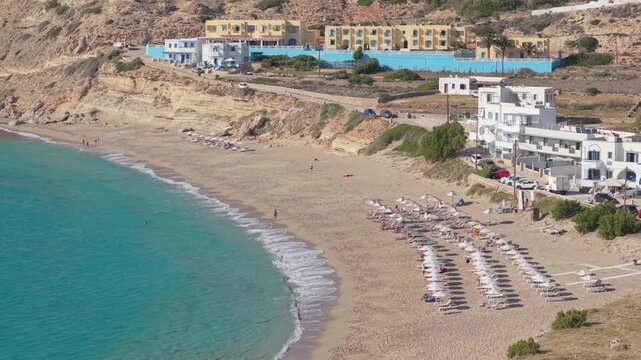 Orbital overhead drone view capturing the pristine golden sandy shoreline of Lefkos Beach and crystal-clear turquoise waters on Karpathos Island, Greece.