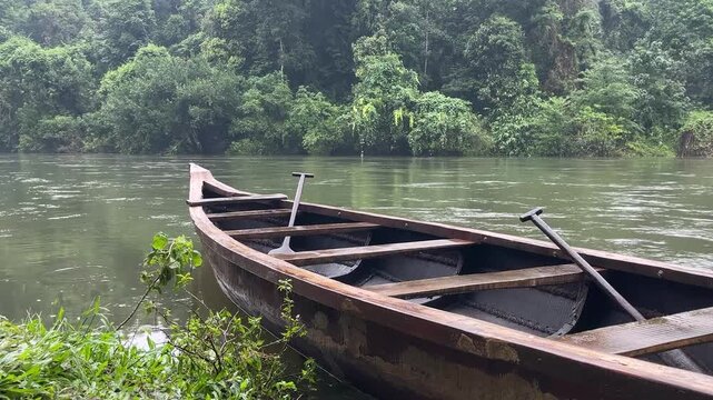 Traditional wooden canoe on tropical rainforest river in 4K