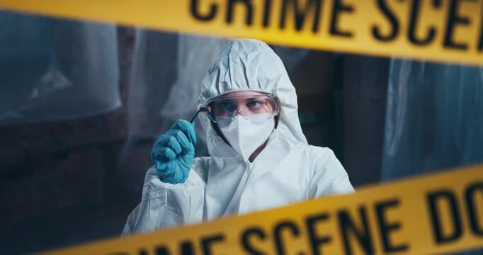 Forensic investigator examines a spent cartridge case before documenting ballistic evidence at a crime scene.