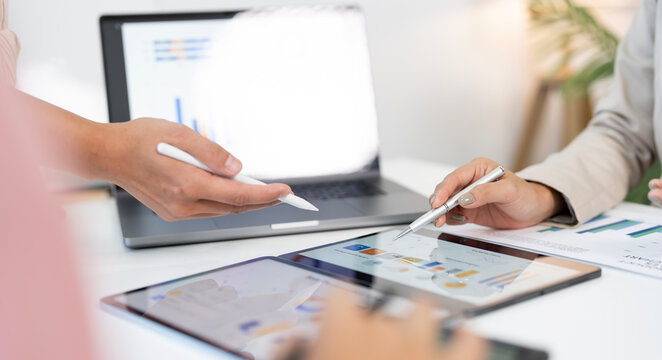 Business partners pointing at financial data on tablet screen during meeting in banner ratio