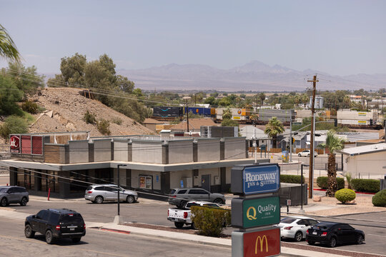 Needles, California, USA - July 28, 2026: Afternoon vehicular and freight train traffic passes through downtown.