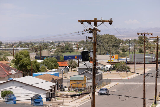 Needles, California, USA - July 28, 2026: Power lines carry electricity to buildings in the downtown area on a sweltering hot day.