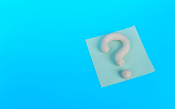White 3D question mark on pale square note with large copy space on blue background
