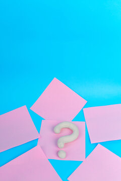 White question mark on pink notes with large copy space on blue background
