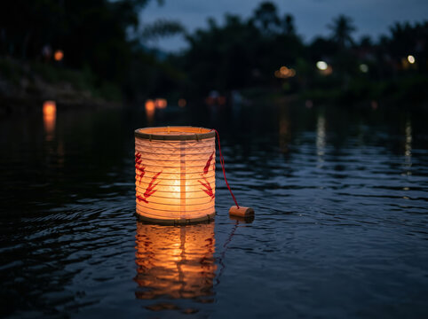 Glowing paper lantern floating alone on dark water surface at night