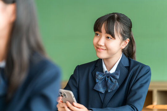 Elementary, middle, and high school students taking online classes using smartphones in school classrooms (ICT education)