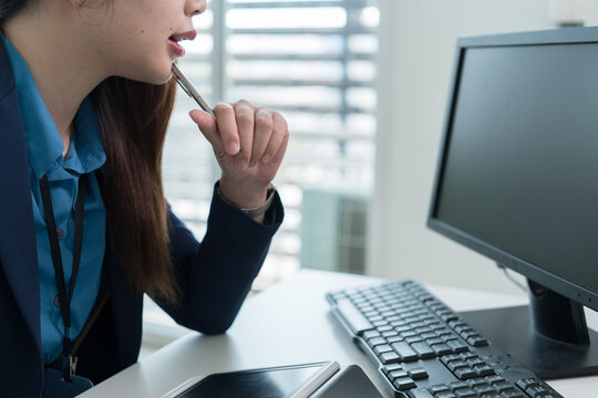 Young Businesswoman Working at Office Desk While Managing Documents and Mobile Communication.