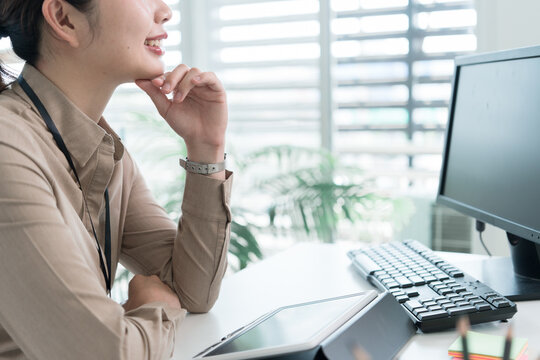Young Businesswoman Working at Office Desk While Managing Documents and Mobile Communication.