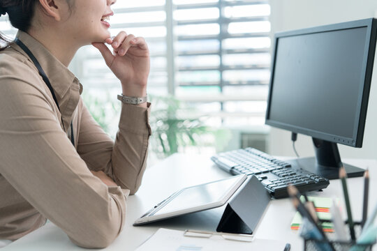 Young Businesswoman Working at Office Desk While Managing Documents and Mobile Communication.