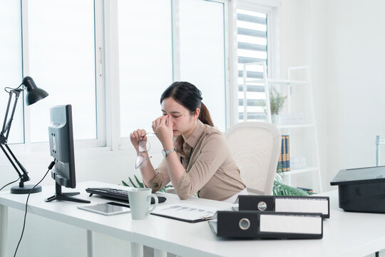 Young Businesswoman Working at Office Desk While Managing Documents and Mobile Communication.