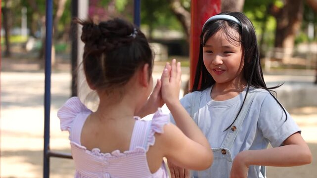 Two Young Asian Girls Playing Clapping Games at Lumpini Park