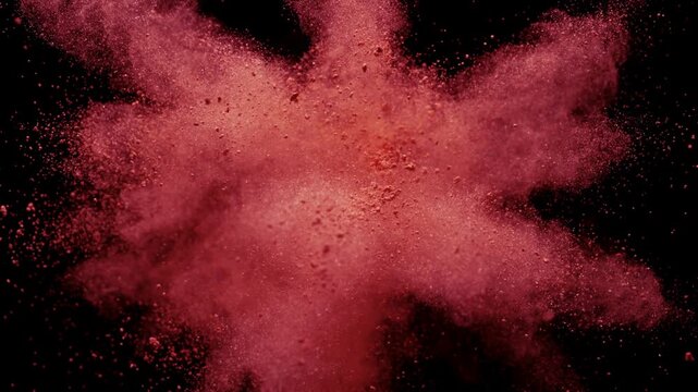 Red Powder Explosion Bursting Against Black Background