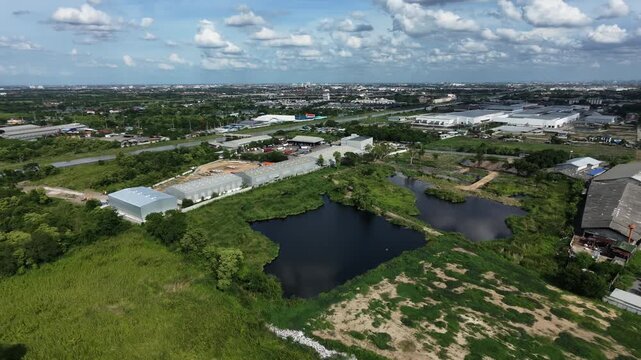 Aerial of the Bangkok suburbs show surrounding agricultural land, roads, communities, and development towards industrial zones.