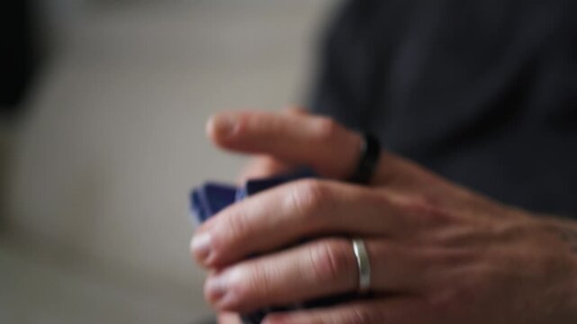 Hands shuffling productivity cards, close up view, indoor setting, selective focus