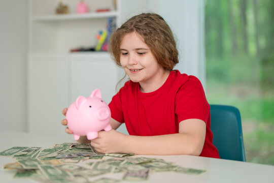 Child counting money and coin indoors. Kid saves dollars using Piggy bank. Smart child supports savings responsibility concepts. Happy kid learns future budgeting skills.
