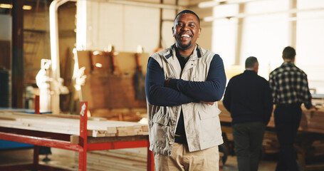 Obraz premium Portrait, carpenter or happy man in workshop with arms crossed, timber manufacturing or craft skills. Person, smile or artisan in factory with confidence, woodwork or about us for carpentry business.