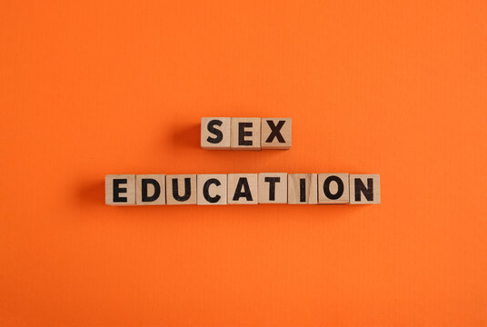 Wooden cubes with text SEX EDUCATION on orange background