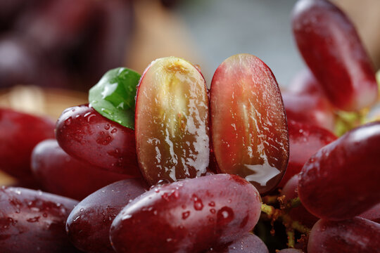 Fresh Red Grapes with Water Droplets Cut in Half Showing Seeds and Juicy Interior