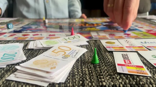 People playing economic board game with play money indoor