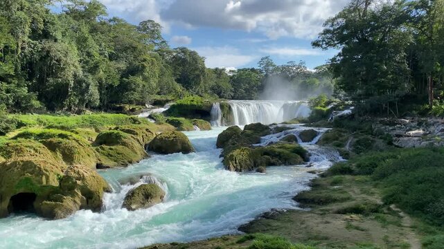 Cinematic shot of the spectacular Cascadas Las Nubes in Chiapas, Mexico, featuring stunning turquoise-blue water flowing over rocky cascades in the lush jungle
