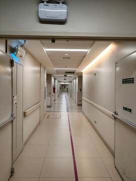 Perspectiva de corredor de interna&ccedil;&atilde;o em hospital moderno com corrim&atilde;o de apoio e faixas de sinaliza&ccedil;&atilde;o em 2026