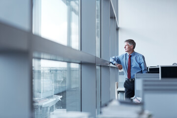 Fototapeta premium Mature, businessman and window with ambition in office building for corporate improvement. Man, employee or thinking with reflection for company growth, development or career opportunity in workplace