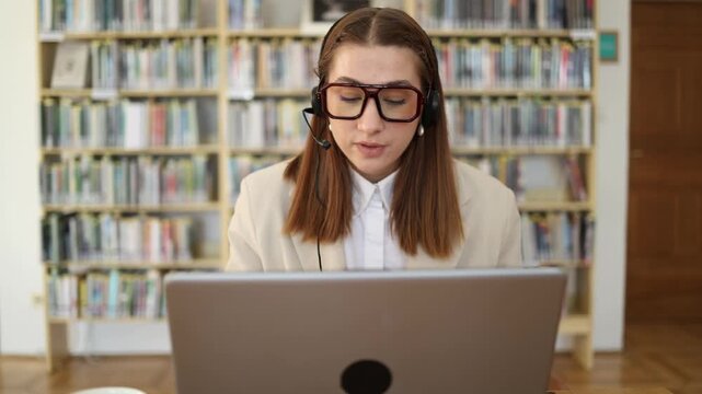Frustrated call center operator in headset reacts emotionally during a difficult customer conversation while working on laptop and trying to resolve a stressful client issue