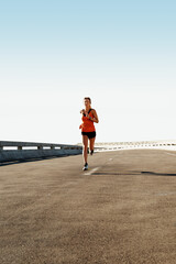 Obraz premium Exercise, woman and running for fitness in road with pace training, morning cardio and practice. Mockup space, athlete and jog on highway bridge for workout routine, endurance or health and wellness