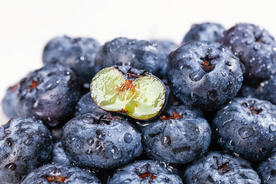 Fresh Blueberries with Water Drops - One Cut Berry Showing Interior Flesh