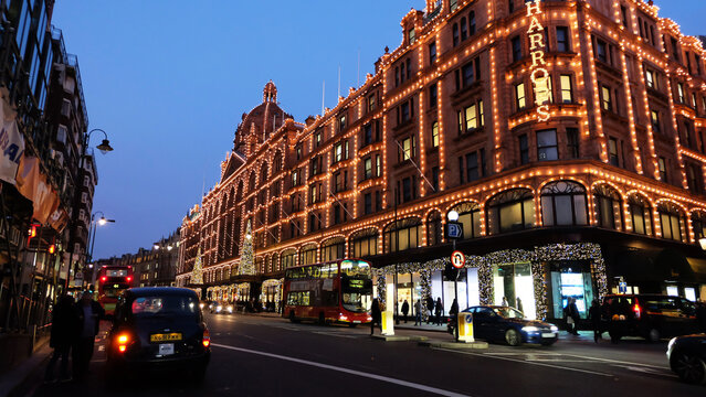 Exterior architecture and frontstore decoration at night of 'HARRODS' famous shopping department store decorated with festive Christmas lighting- England, UK