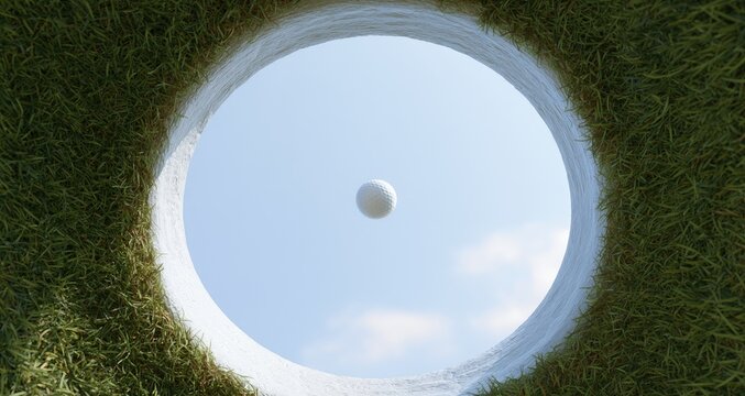 Golf ball suspended in the air above a green golf course hole.