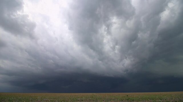 A supercell storm slowly rotates in the sky as it approaches in this time lapse video.