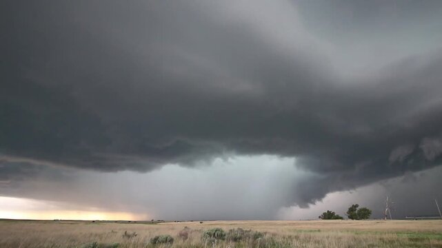 A powerful storm gathers strength as it churns in the sky over the plains, dropping rain and hail. Time lapse.