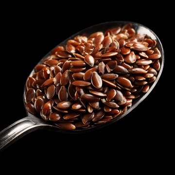 Glossy brown flax seeds on spoon on a dark background with clipping path, depicting natural texture and organic nutrition concept
