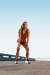 Obraz premium Runner, woman and break in city with earphones, thinking and listen to music playlist for exercise. Space, female person and fitness in street outdoor with audio tech, radio and workout for wellness.