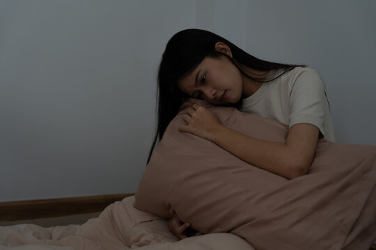 woman in bed late trying to sleep suffering insomnia, sleepless or scared in a nightmare, looking sad worried and stressed. Tired and headache or migraine waking up in the middle of the night.
