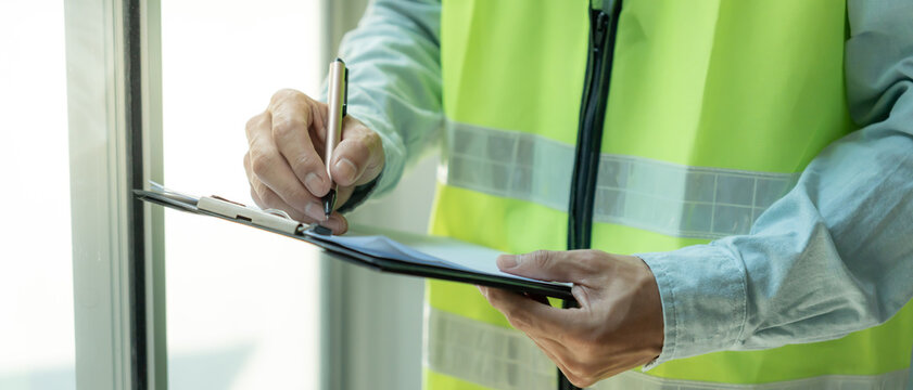 inspector or engineer is inspecting construction and quality assurance new house using a checklist. Engineers or architects or contactor work to build the house before handing it over to the homeowner