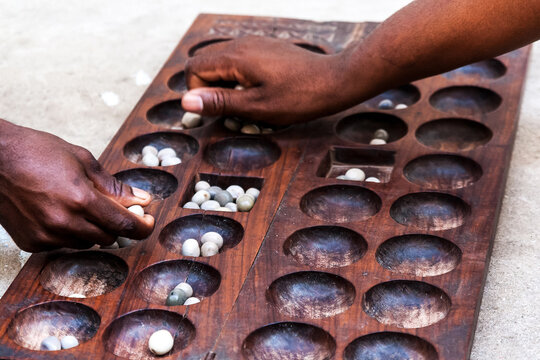 Hands playing Mancala game, Stone town, Tanzania. Mancala is a game which is very popular in Africa and Arabs