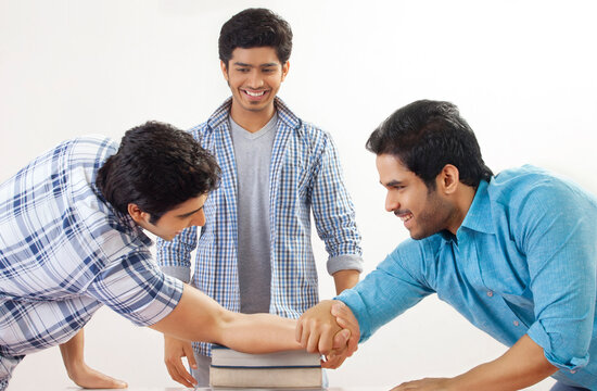 Three friends arm wrestling