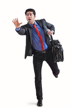 Young businessman holding briefcase and running