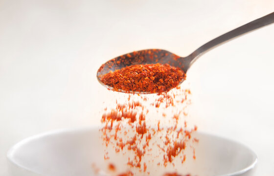 Chilli powder being poured from spoon