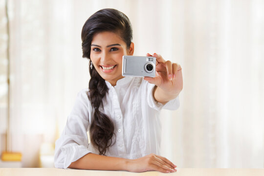 Young woman taking photograph with camera