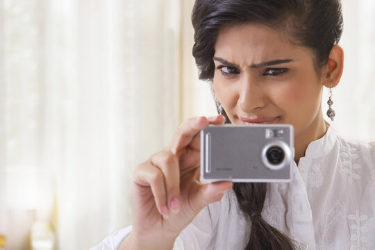 Young woman taking photograph with camera