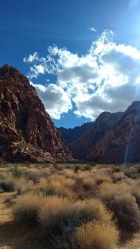 Scenic Red Rock Canyon landscape with blue sky and clouds.