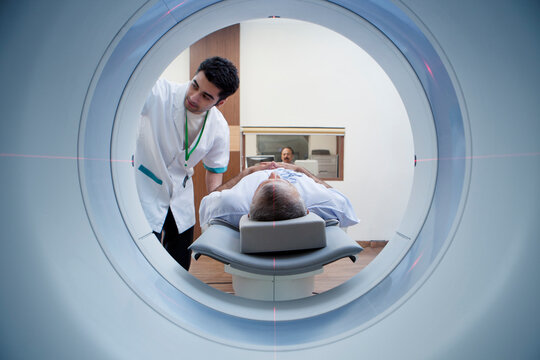 Medical technician with patient on CT scanner