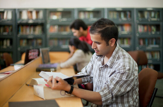 Teenager reading a book in a library