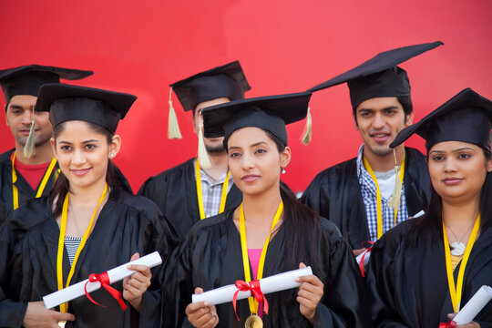 Graduate students holding diplomas