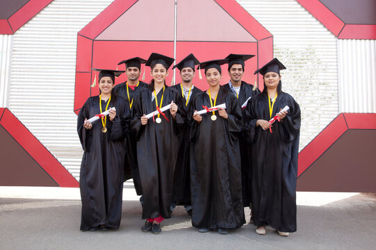 Portrait of graduate students with diploma