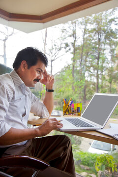 Man thinking while working on laptop
