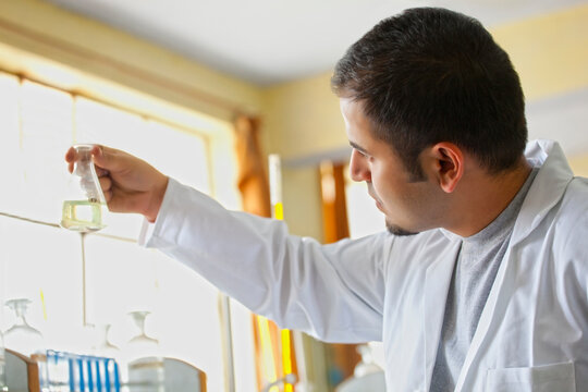 College student holding a beaker with liquid